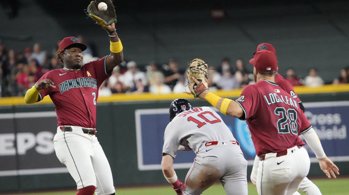 Boston Red Sox infielder Trevor Story (10) ducks under a tag by Arizona Diamondbacks shortstop Geraldo Perdomo (2) during a rundown during the seventh inning at Chase Field on Sept. 7, 2025. Story was safe at second.
