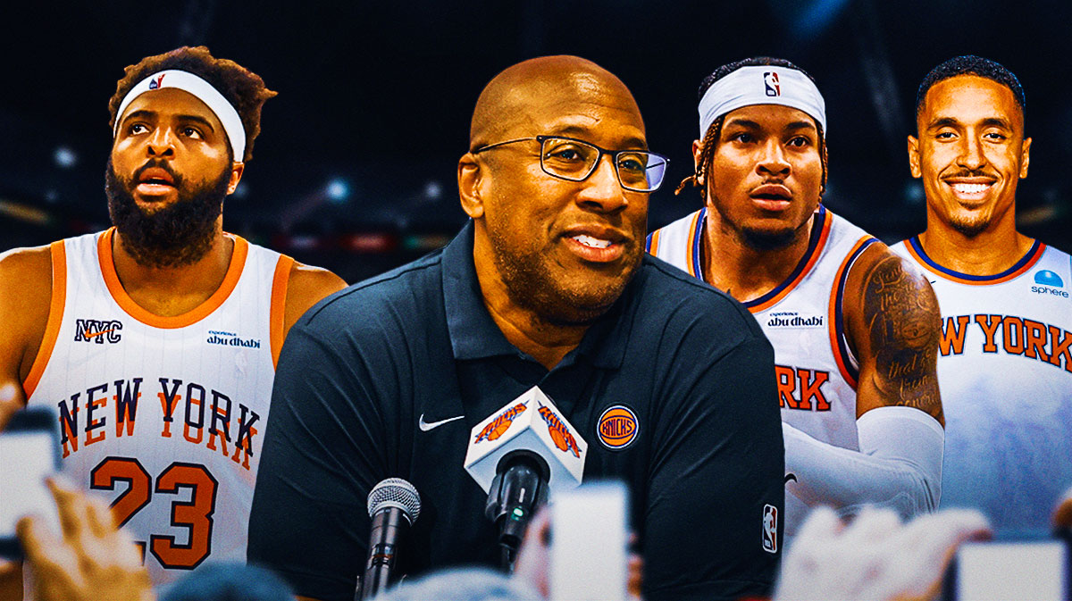 Mike Brown thinking pensively with Mitchell Robinson, Miles McBride, and Malcolm Brogdon surrounding him New York Knicks