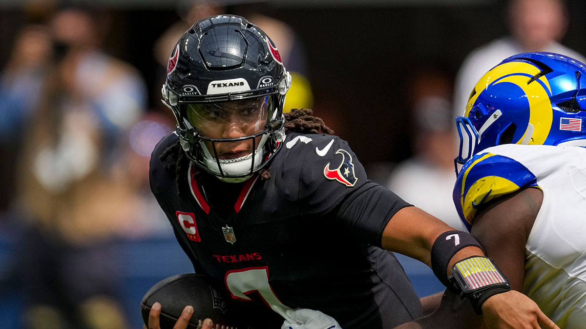 Houston Texans quarterback C.J. Stroud (7) tries to escape the tackle of Los Angeles Rams linebacker Byron Young (0) at SoFi Stadium.