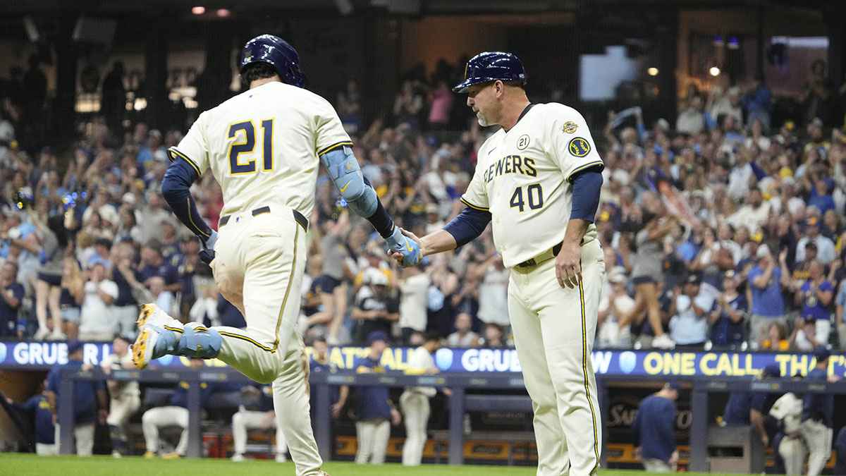Milwaukee Brewers outfielder Christian Yelich (22) is congratulated by third base coach Jason Lane (40) after hitting a home run against the Los Angeles Angels in the fourth at American Family Field.