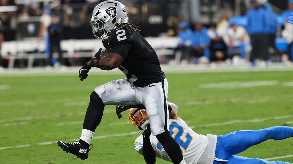 Las Vegas Raiders running back Ashton Jeanty (2) evades a tackle from Los Angeles Chargers safety Alohi Gilman (32) during the first quarter at Allegiant Stadium.