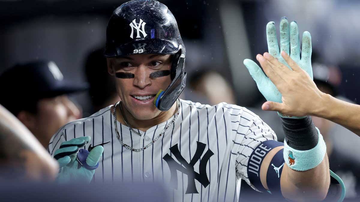 New York Yankees right fielder Aaron Judge (99) celebrates his solo home run against the Chicago White Sox with teammates in the dugout during the eighth inning at Yankee Stadium.