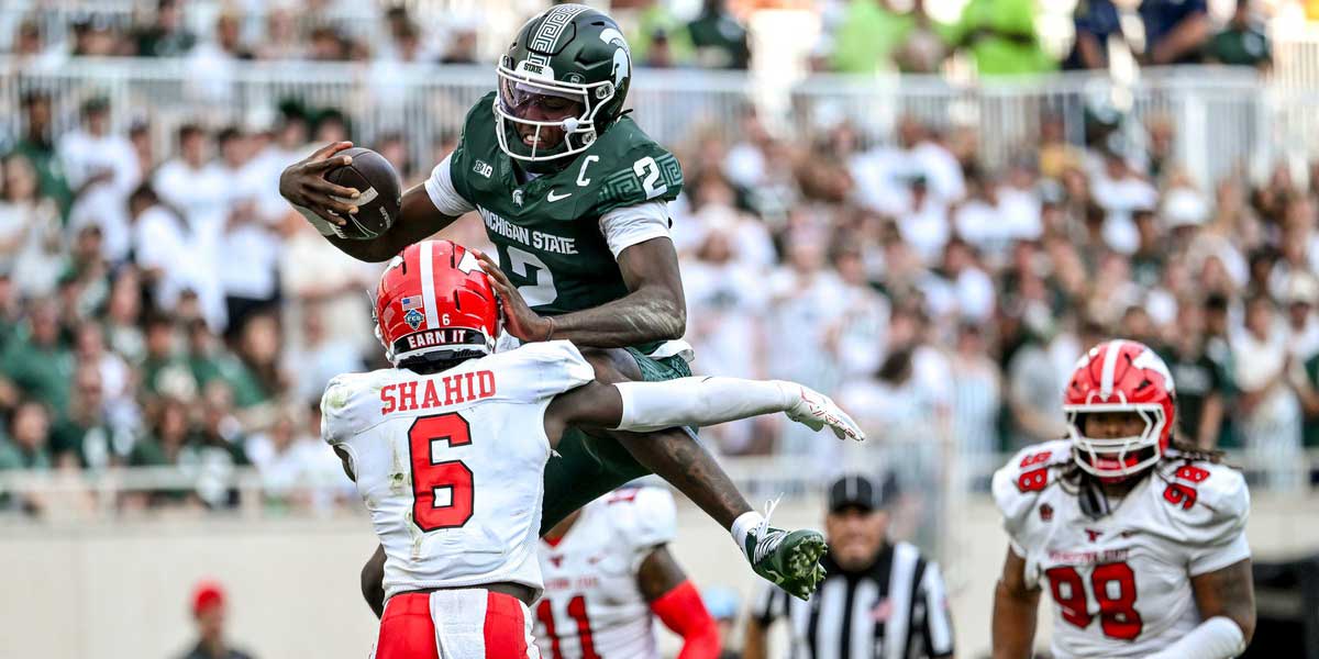Michigan State's Aidan Chiles, top, tries to leap over Youngstown State's Makai Shahid on a run during the fourth quarter on Saturday, Sept. 13, 2025, at Spartan Stadium in East Lansing.