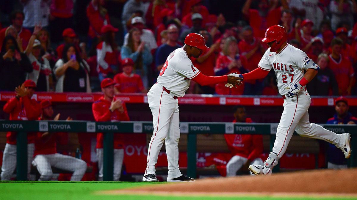 Los Angeles Angels designated hitter Mike Trout (27) is greeted by third base coach Bo Porter (88) after hitting a solo home run against the Houston Astros during the eighth inning at Angel Stadium.