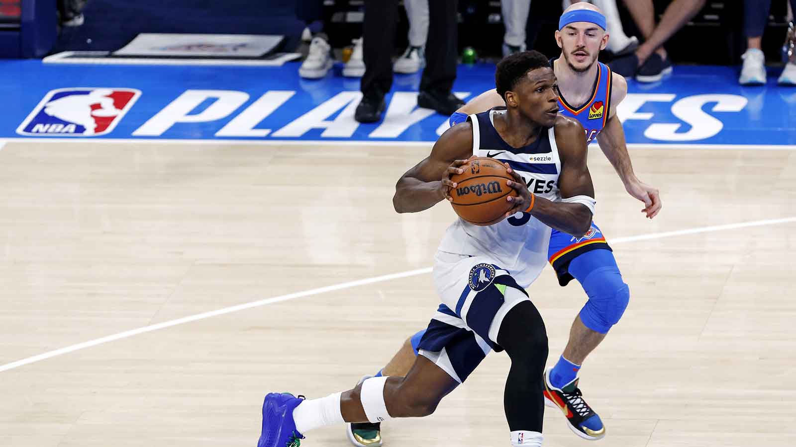 Minnesota Timberwolves guard Anthony Edwards (5) drives to the basket against Oklahoma City Thunder guard Alex Caruso (9) during the third quarter in game five of the western conference finals for the 2025 NBA Playoffs at Paycom Center. 