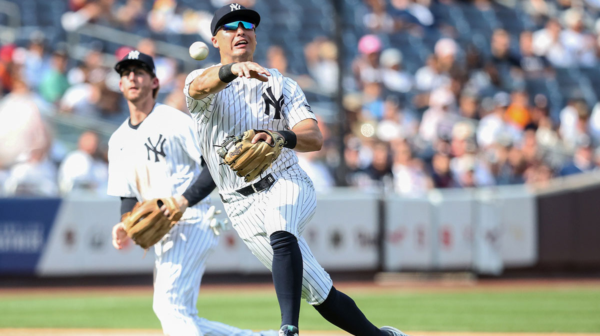 Aug 10, 2025; Bronx, New York, USA; New York Yankees shortstop Anthony Volpe (11) attempts to throw a runner out at first base in the ninth inning against the Houston Astros at Yankee Stadium. 