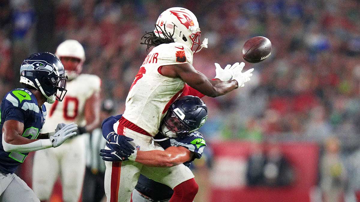 Arizona Cardinals receiver Marvin Harrison Jr. (18) drops a pass while being hit by Seattle Seahawks linebacker Drake Thomas (42) at State Farm Stadium in Glendale on Sept. 25, 2025.
