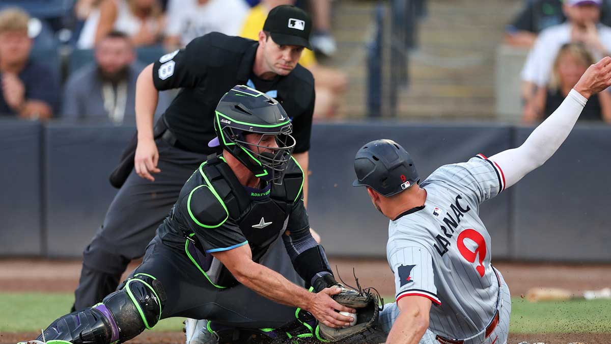 Minnesota Twins right fielder Trevor Larnach (9) scores a Rin past Tampa Bay Rays catcher Ben Rortvedt (30) in the first inning at George M. Steinbrenner Field.