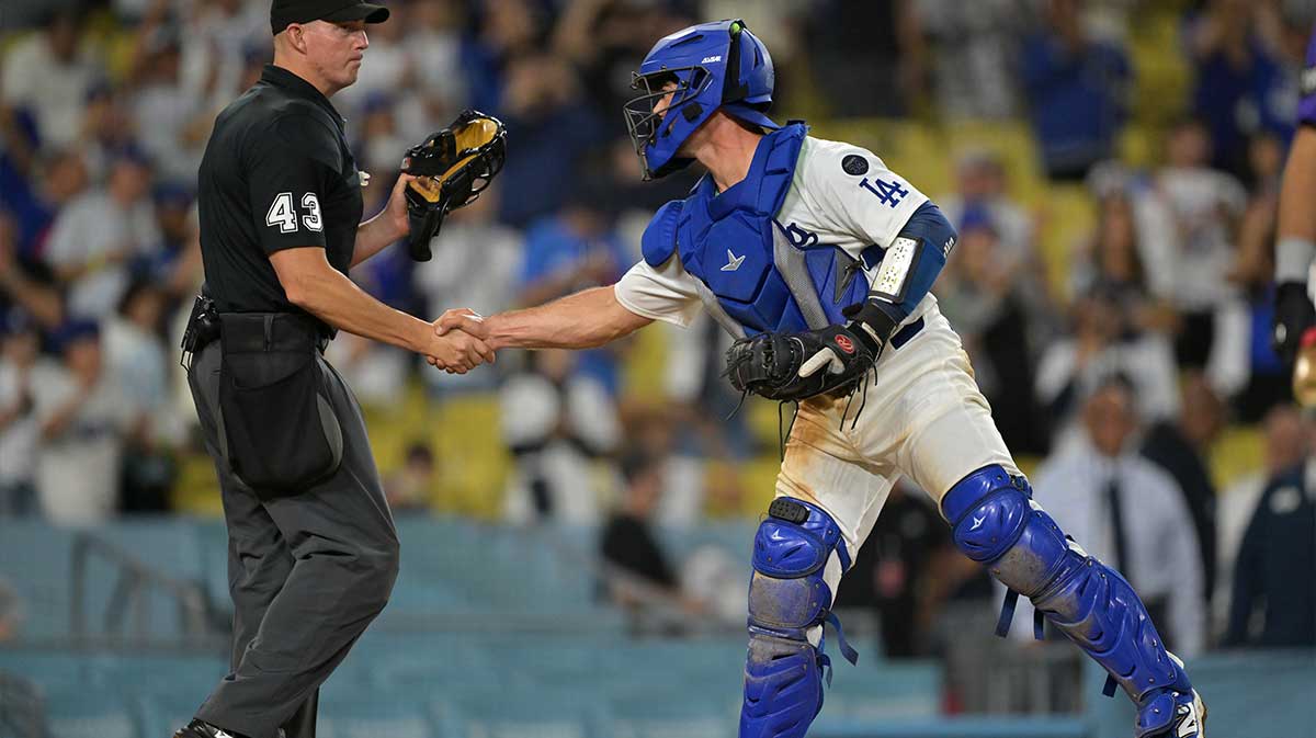 Los Angeles Dodgers catcher Ben Rortvedt (47) shakes hands with umpire Shane Livensparger (43) after the final out of the game against the Colorado Rockies at Dodger Stadium.