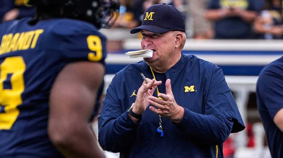 Michigan acting head coach Biff Poggi watches warm up before the Central Michigan game at Michigan Stadium
