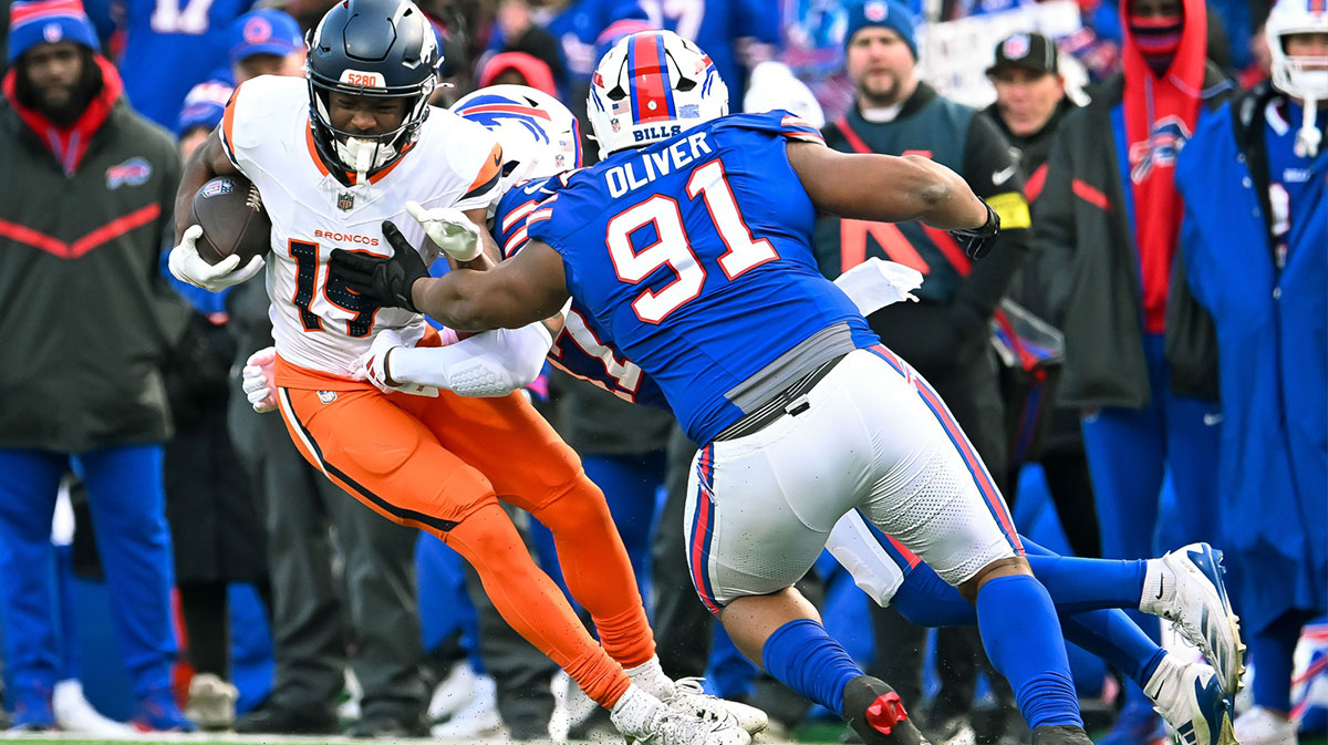 Denver Broncos wide receiver Marvin Mims Jr. (19) is tackled by Buffalo Bills defensive tackle Ed Oliver (91) and cornerback Christian Benford (47) in the fourth quarter of an AFC wild card game at Highmark Stadium.