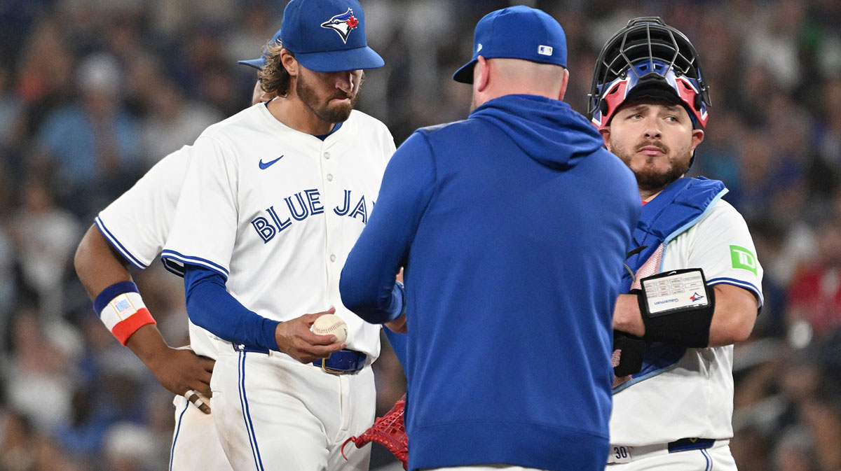 Toronto Blue Jays pitcher Kevin Gausman (34) hands the ball to manager John Schneider (14) as he is relieved in the sixth inning against the Boston Red Sox at Rogers Centre.