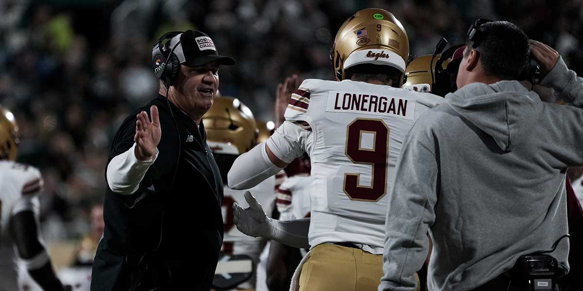 Boston College head coach Bill O'Brien celebrates with Boston College quarterback Dylan Lonergan (9) after a scoring drive in the second quarter at Spartan Stadium.
