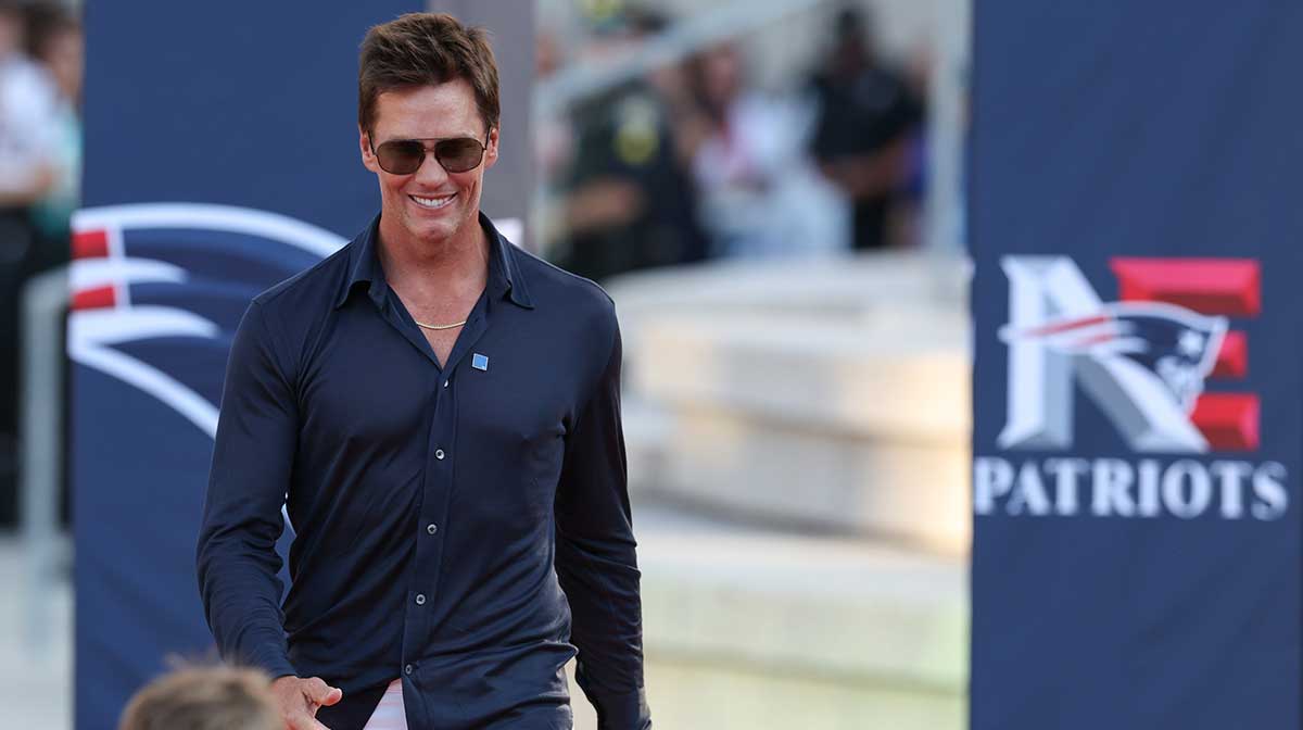 Retired New England Patriot Hall of Famer Tom Brady speaks during a statue unveiling before a game against the Washington Commanders at Gillette Stadium.