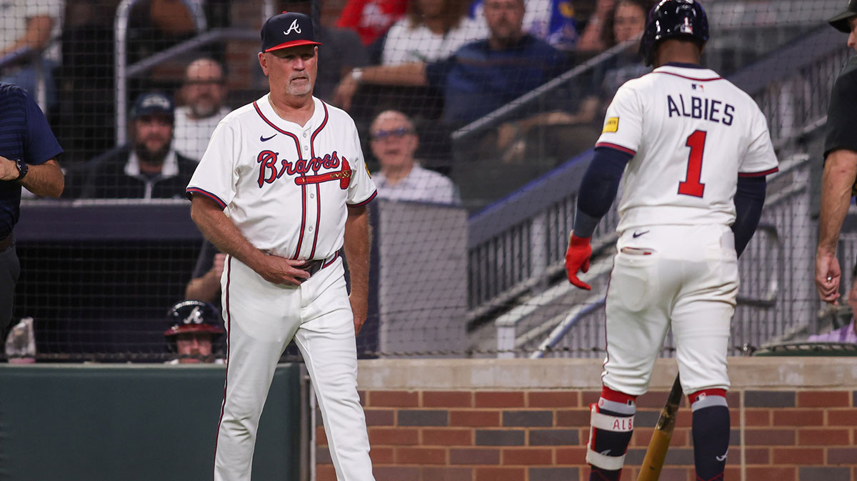 Atlanta Braves manager Brian Snitker (43) checks on second baseman Ozzie Albies (1) against the Washington Nationals in the third inning at Truist Park.