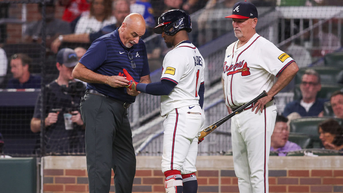 Atlanta Braves trainer George Poulis works on second baseman Ozzie Albies (1) against the Washington Nationals in the third inning at Truist Park.
