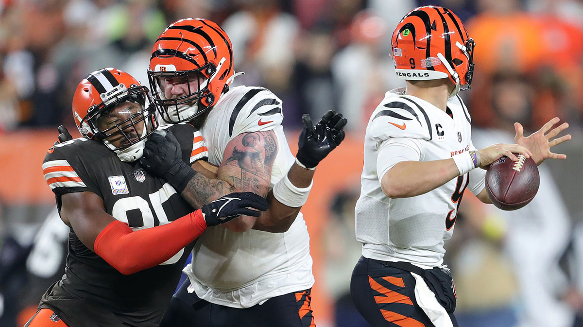 Cincinnati Bengals quarterback Joe Burrow (9) passes under pressure from Cleveland Browns defensive end Myles Garrett (95) during the second half of an NFL football game at FirstEnergy Stadium