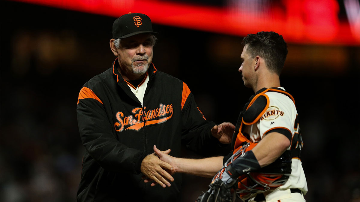 San Francisco Giants catcher Buster Posey (28) celebrates with manager Bruce Bochy (15) after defeating the Oakland Athletics at Oracle Park.