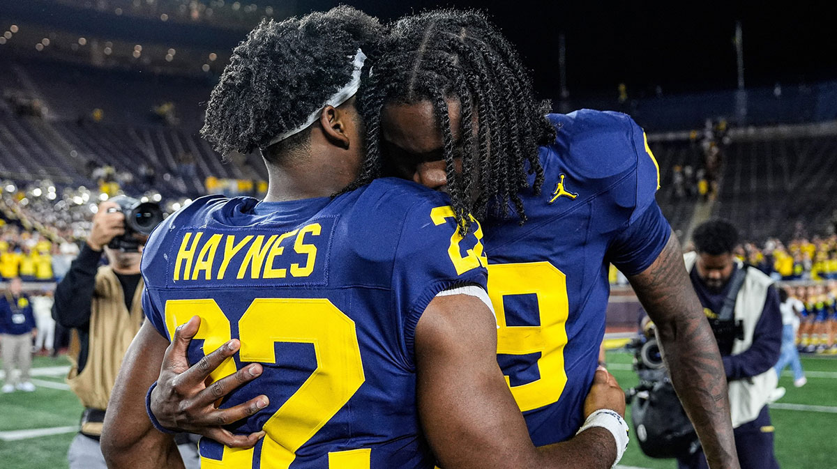 Michigan quarterback Bryce Underwood hugs running back Justice Haynes on the field after the 34-17 win over New Mexico at Michigan Stadium.