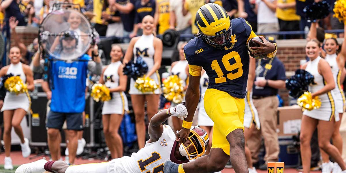 Michigan quarterback Bryce Underwood (19) runs for a touchdown against Central Michigan defensive back Caleb Spann (15) during the first half at Michigan Stadium