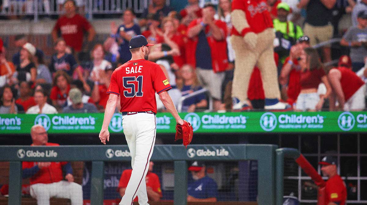Atlanta Braves starting pitcher Chris Sale (51) walks off the field as mascot Blooper looks on against the Seattle Mariners in the seventh inning at Truist Park.