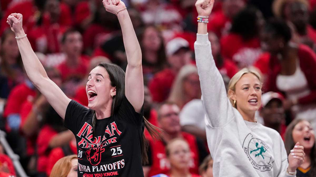 Indiana Fever stars Caitlin Clark and Sophie Cunningham, who are not playing in the playoff series against the Las Vegas Aces.