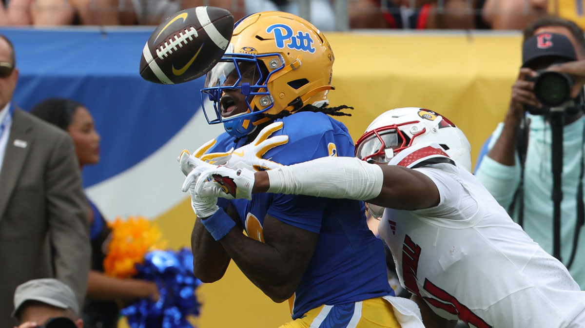 Pittsburgh Panthers wide receiver Cataurus Hicks (3 ) catches a touchdown pass as Louisville Cardinals defensive back Jabari Mack (4) defends during the first quarter at Acrisure Stadium.