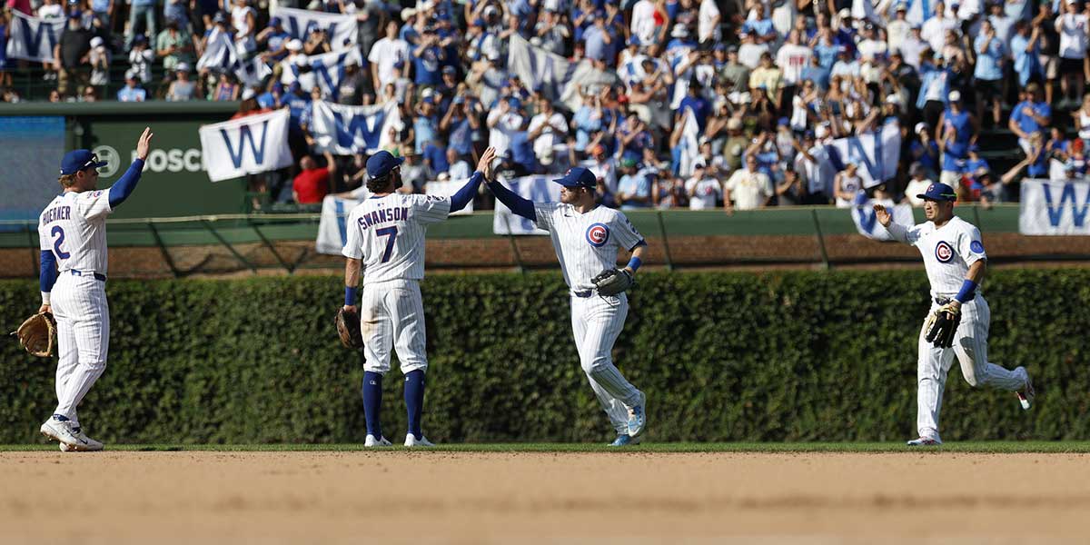Chicago Cubs players celebrate after defeating the St. Louis Cardinals in a baseball game at Wrigley Field.