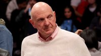 Clippers owner Steve Ballmer leaves his court side seat after a game against the Brooklyn Nets at Barclays Center with ESPN's Brian Windhorst in the background