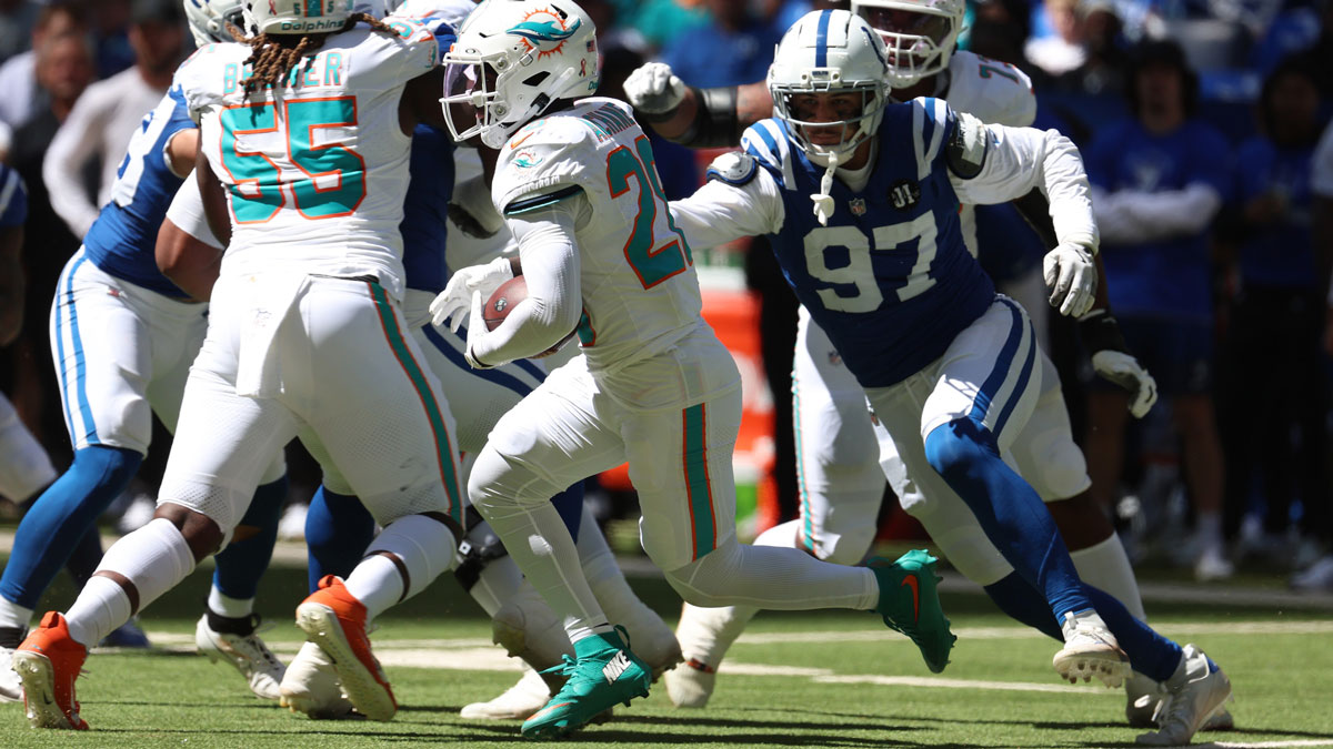 Miami Dolphins running back De'Von Achane (28) runs against Indianapolis Colts defensive end Laiatu Latu (97) during the first half at Lucas Oil Stadium.