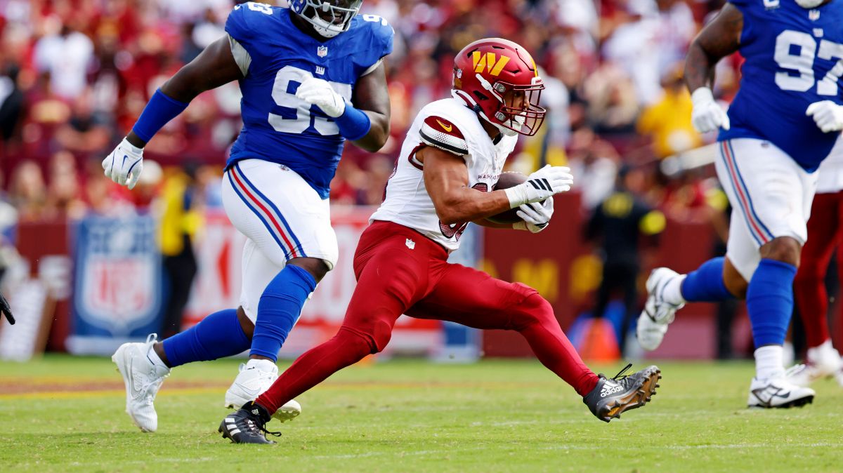 Washington Commanders running back Austin Ekeler (30) makes a run against the New York Giants during the fourth quarter at Northwest Stadium.