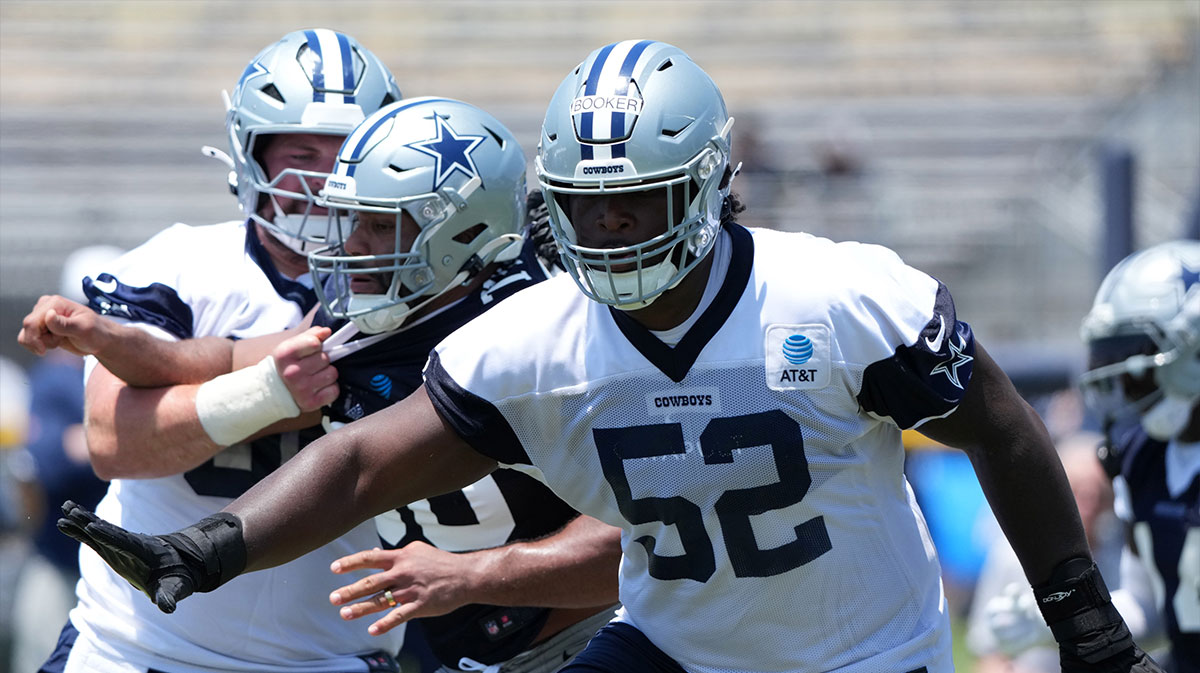Cowboys guard Tyler Booker (52) during training camp at the River Ridge Fields with Jalen Carter in the background and Klayton Adams