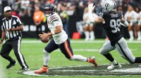 Chicago Bears quarterback Caleb Williams (18) looks for an open receiver while being pressured by Las Vegas Raiders defensive end Maxx Crosby (98) in the second quarter at Allegiant Stadium.
