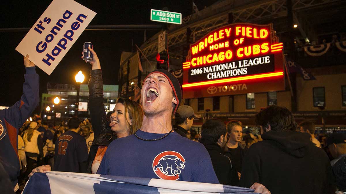 A Chicago Cubs fan hold a \"W\" flag as he celebrates outside Wrigley Field after the Cubs won the National League pennant in 2016. Cubs fans