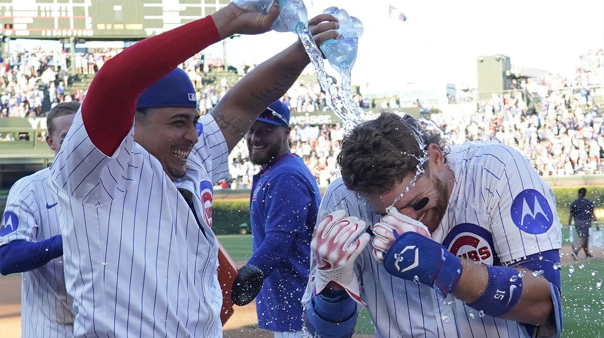 Chicago Cubs catcher Carson Kelly (15) is doused with water from pitcher Daniel Palencia (48) after hitting a game winning single against the Atlanta Braves at Wrigley Field.
