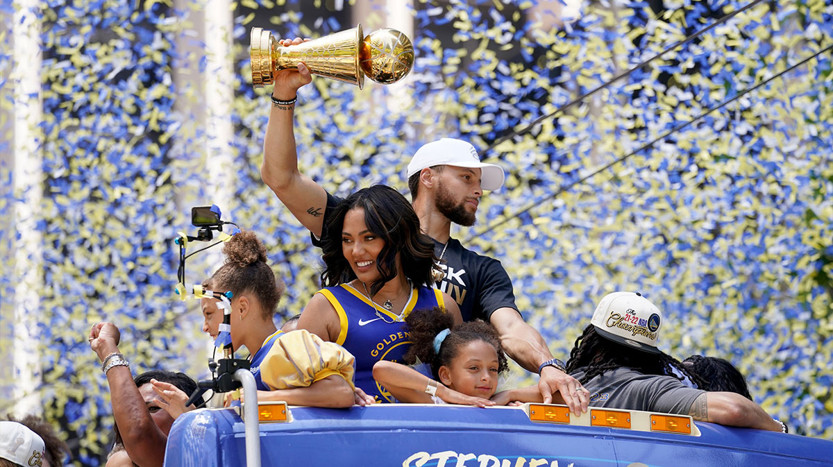 Golden State Warriors guard Stephen Curry holds the NBA Finals Most Valuable Player Award trophy next to his wife Ayesha during the Warriors championship parade in downtown San Francisco.