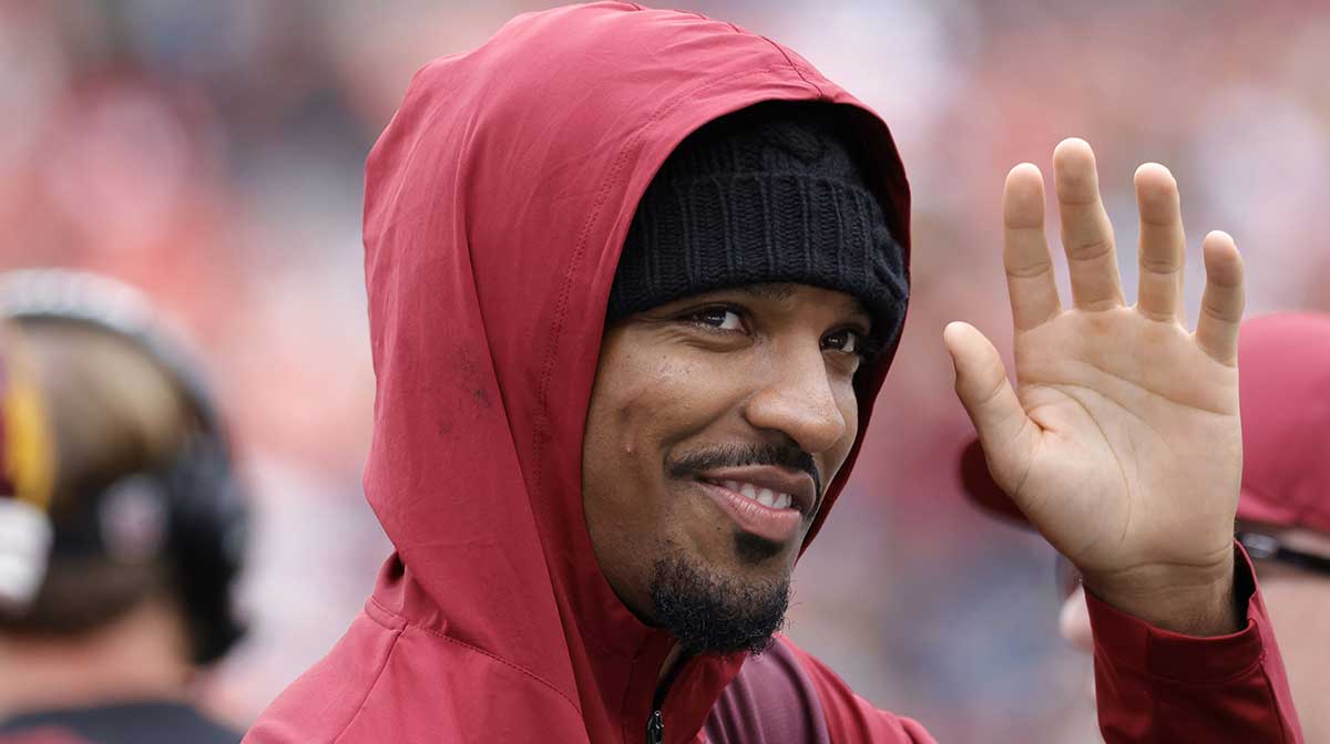 Injured Washington Commanders quarterback Jayden Daniels waves to fans while walking off the field after the Commanders' game against the Las Vegas Raiders at Northwest Stadium.