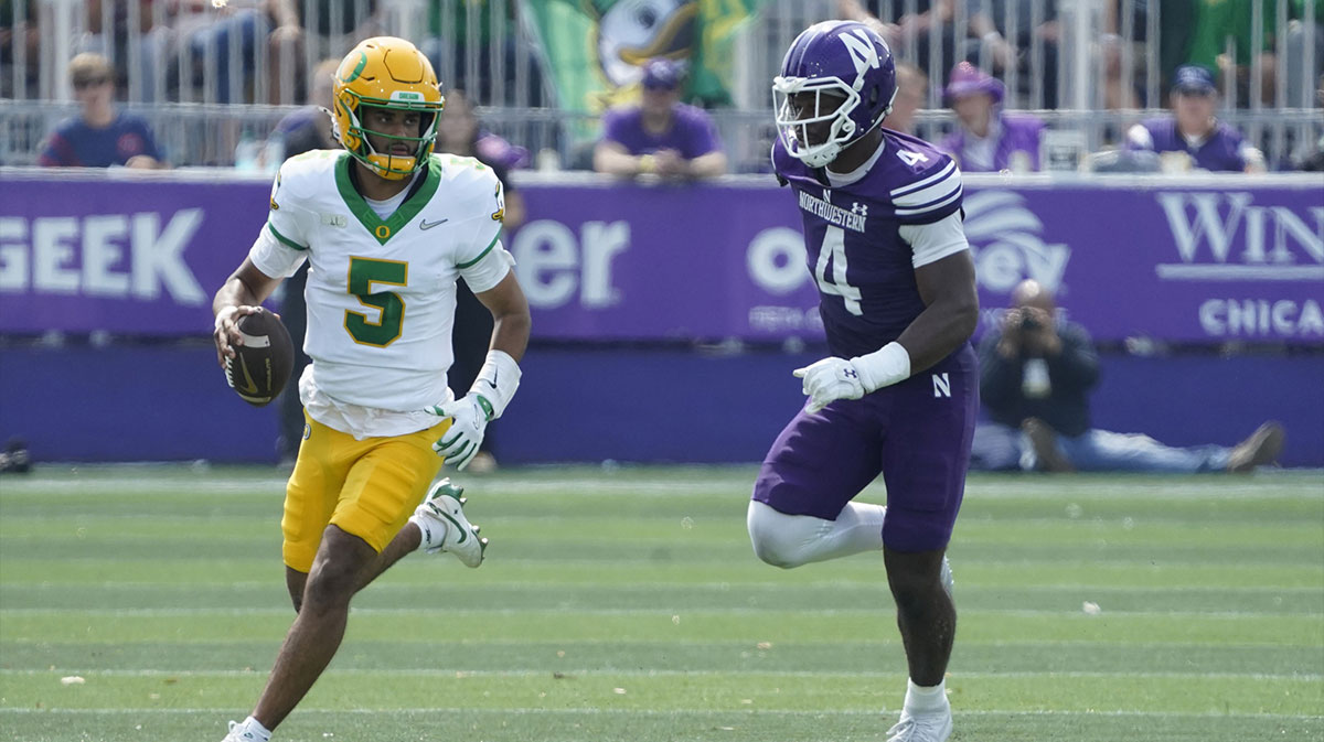 Oregon Ducks quarterback Dante Moore (5) runs the ball past Northwestern Wildcats defensive lineman Anto Saka (4) during the first half at Northwestern Medicine Field at Martin Stadium.