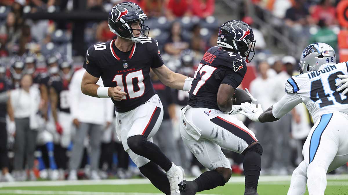 Houston Texans quarterback Davis Mills (10) hands off to running back Woody Marks (27) during the second quarter against the Carolina Panthers