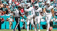 Miami Dolphins running back De'Von Achane (28) reacts with wide receiver Tyreek Hill (10) after scoring a touchdown against the New England Patriots in the second quarter at Hard Rock Stadium.