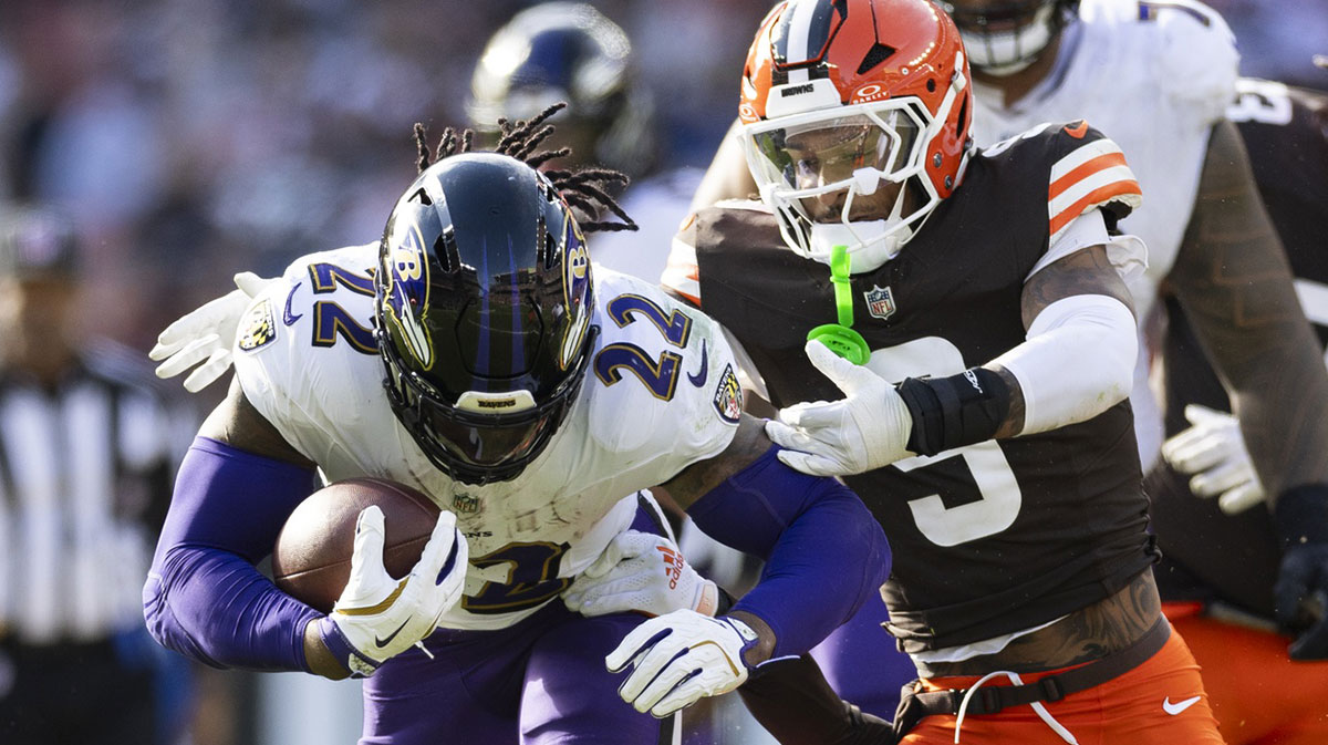 Baltimore Ravens running back Derrick Henry (22) runs the ball as Cleveland Browns safety Grant Delpit (9) tackles him during the fourth quarter at Huntington Bank Field.