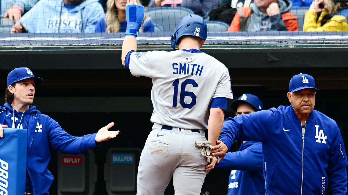 Dodgers catcher Will Smith (16) celebrates after scoring with manager Dave Roberts, right, during the fourth inning against the Cleveland Guardians at Progressive Field