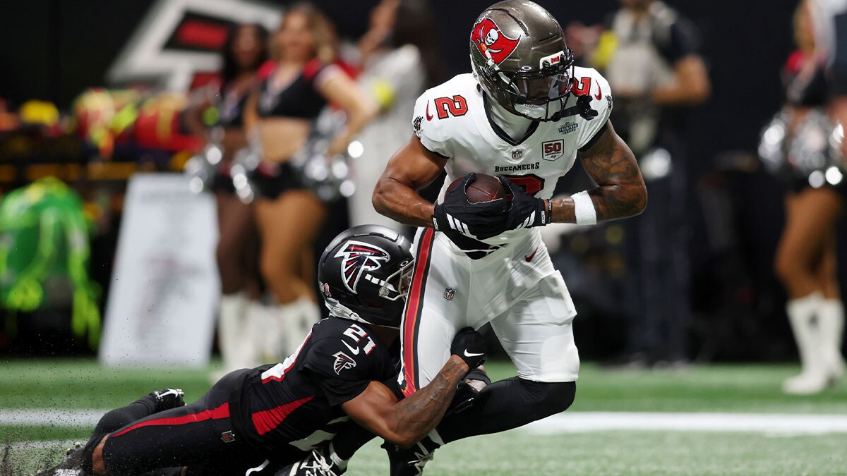 Tampa Bay Buccaneers wide receiver Emeka Egbuka (2) runs with the ball for a touchdown against Atlanta Falcons cornerback Mike Hughes (21) during the second quarter at Mercedes-Benz Stadium.