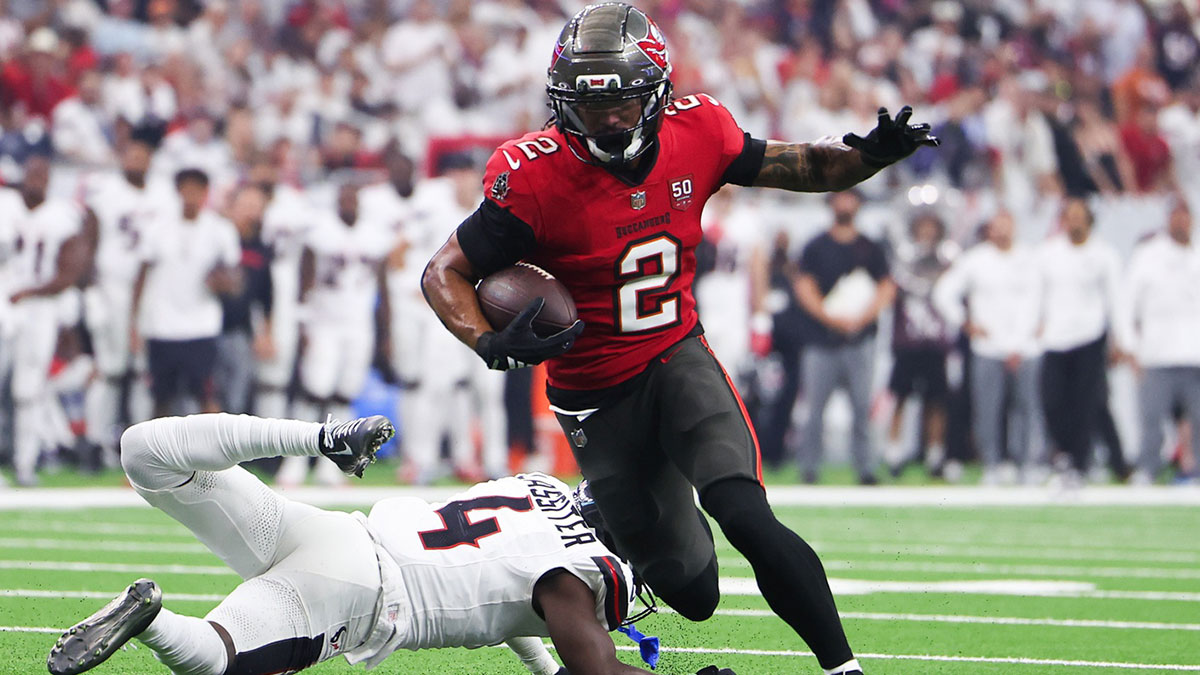 Tampa Bay Buccaneers wide receiver Emeka Egbuka (2) runs for a touchdown as Houston Texans cornerback Kamari Lassiter (4) defends during the second quarter at NRG Stadium
