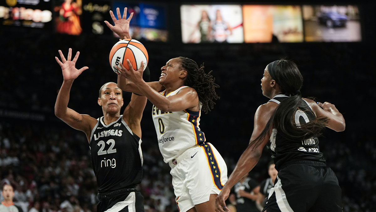 Indiana Fever guard Kelsey Mitchell (0) attempts to score a layup against Las Vegas Aces center A'ja Wilson (22) and guard Jackie Young (0) during the second quarter in game one of the second round for the 2025 WNBA Playoffs at Michelob Ultra Arena.