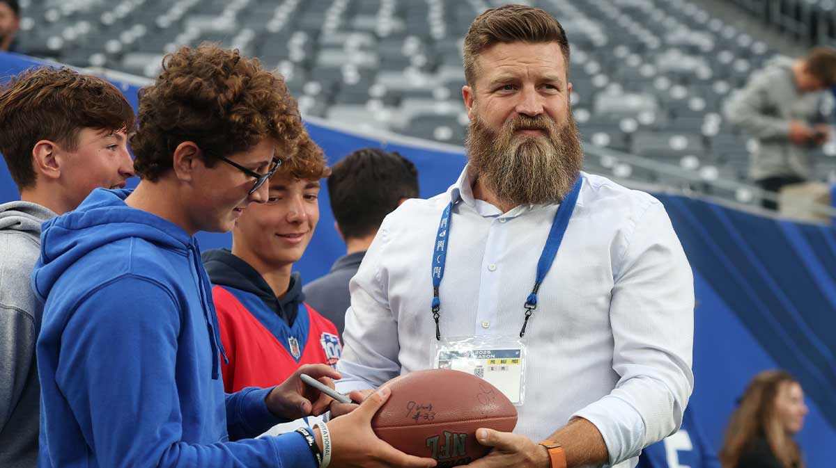 Retired NFL quarterback and member of the Prime Thursday night football crew, Ryan Fitzpatrick, with fans before the preseason game between the New York Giants and the New England Patriots at MetLife Stadium