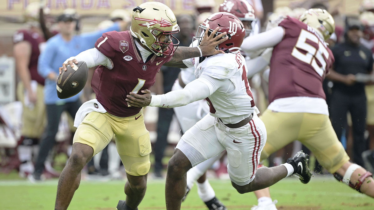Florida State Seminoles quarterback Tommy Castellanos (1) stiff arms Alabama Crimson Tide linebacker Justin Jefferson (10) during the second half at Doak S. Campbell Stadium.