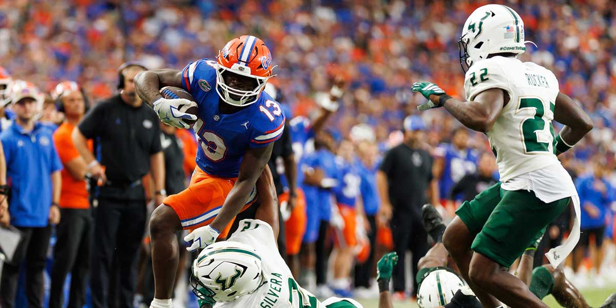 Florida Gators running back Jadan Baugh (13) rushes with the ball past South Florida Bulls safety Jabari Smith (12) during the second half at Ben Hill Griffin Stadium.