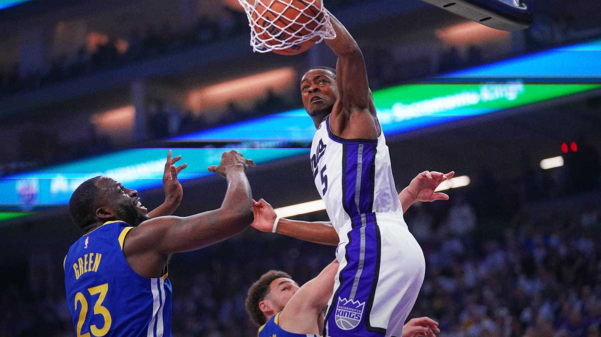 Sacramento Kings guard De'Aaron Fox (5) dunks the ball over Golden State Warriors forward Draymond Green (23) in the first quarter during a play-in game of the 2024 NBA playoffs at the Golden 1 Center.