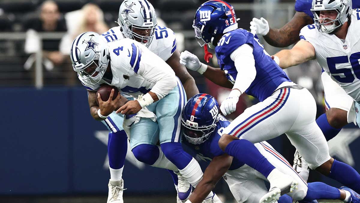 New York Giants linebacker Brian Burns (0) tackles Dallas Cowboys quarterback Dak Prescott (4) during the second quarter at AT&T Stadium. 